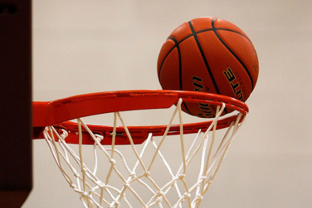 A basketball barely misses the rim as the ball sails into the net